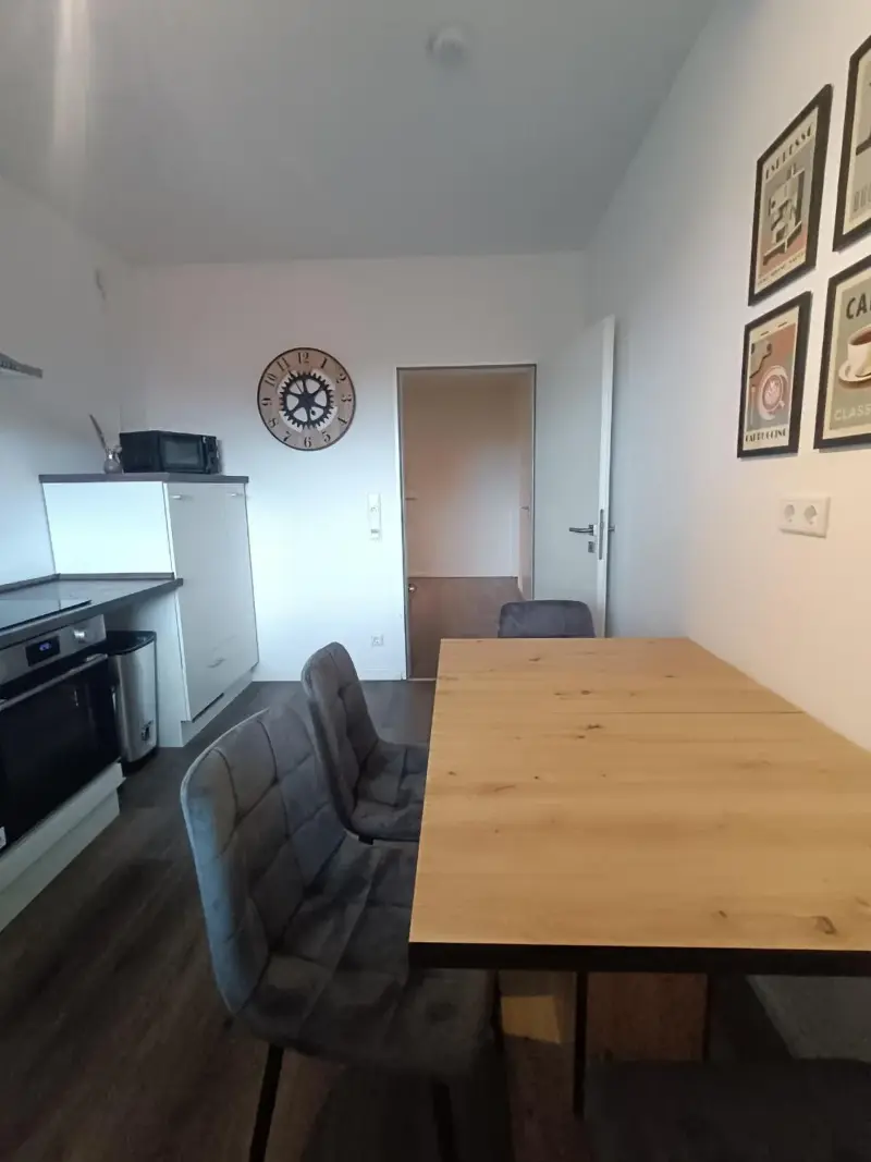 Küche mit Backofen, Kühlschrank und Esstisch